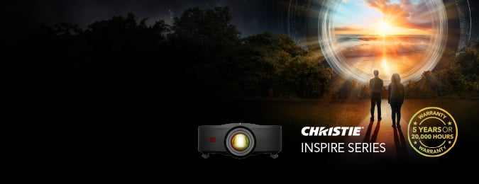 A silhouette of two people seen from behind looking at a sunset and in the foreground is an Inspire projector and a 5-year warranty icon