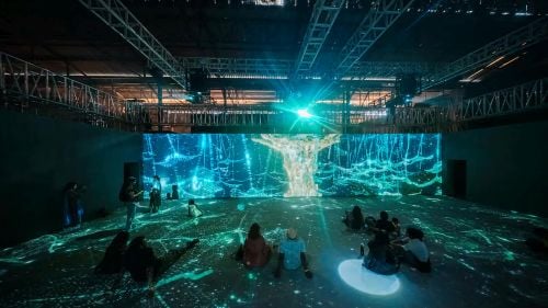 An immersive rooom with projection mapped designs on a large screen