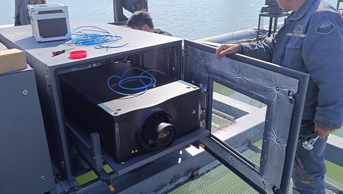 Engineers from Beijing Zhongqing Display Technology installing the Crimson WU32 projectors in weatherproof enclosures