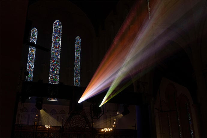 Truss-mounted projectors (left) displayed Earth-to-cosmos visuals across the church’s soaring arches, vaulted ceilings and stained-glass windows (right).