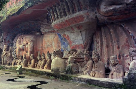 Sculptures of people from the waist up carved into rock.