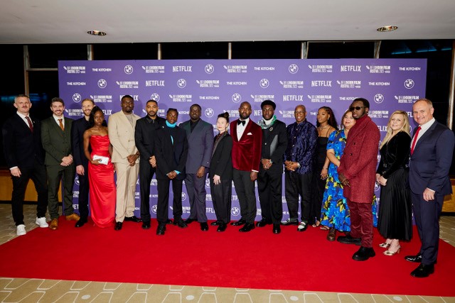 A diverse group of people standing on a red carpet at the BFI closing night gala