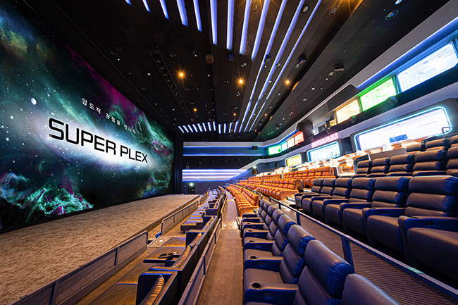 Image of a movie theatre with the screen on the left and stadium seating on the right.  