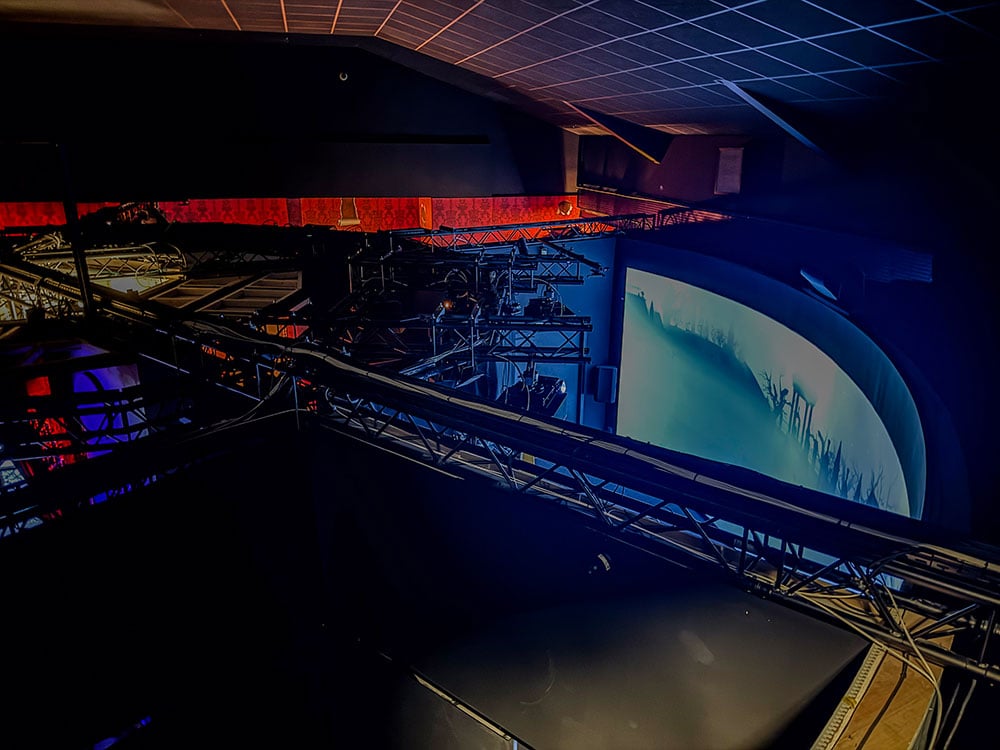 An overhead view of a truss and a large, curved screen.