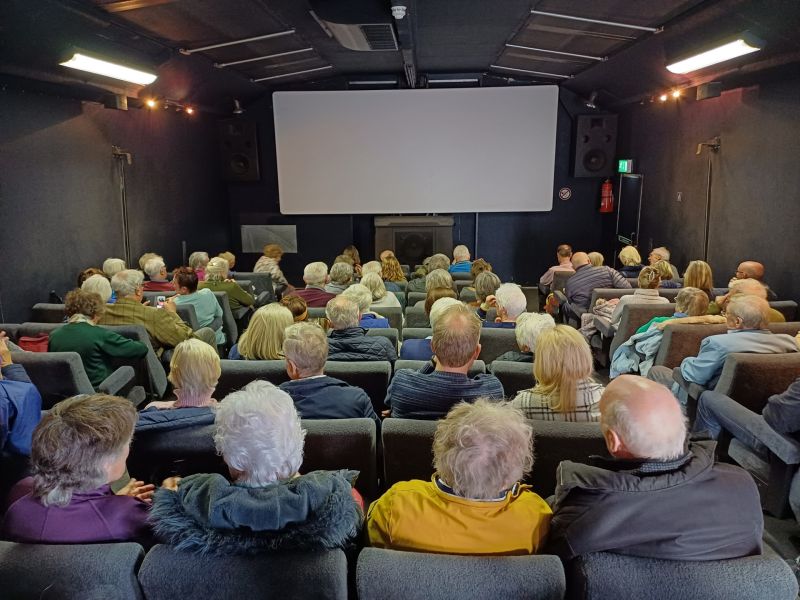 A packed movie theatre looking towards the screen at the front.