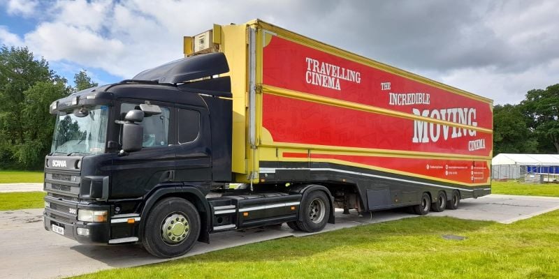 A transport truck with a red trailer.