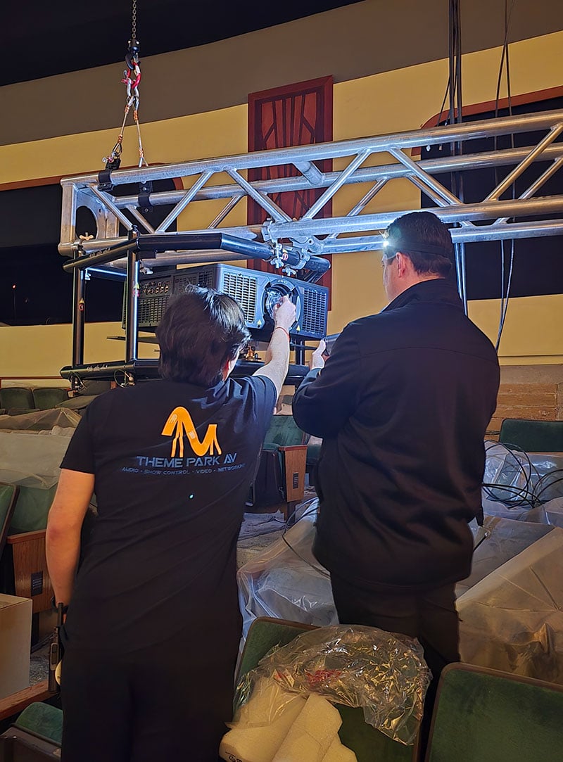 Two people rig a 1DLP projector.