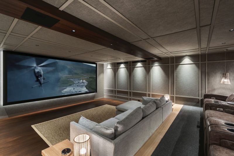 A home theater with a sectional facing a large movie screen.