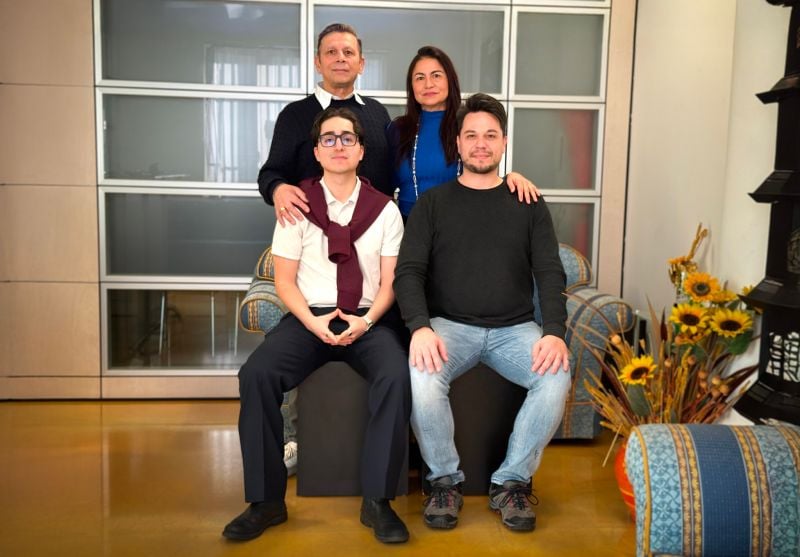 A portrait of a man and woman standing in front of two seated men.