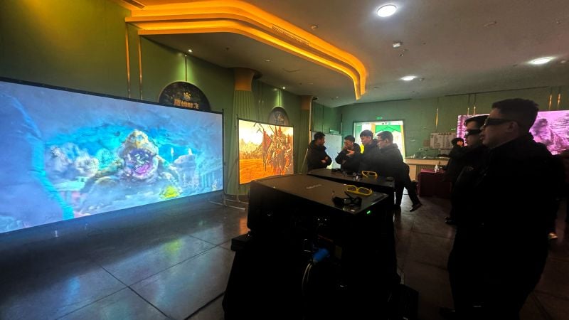 A group watches the projected, blended image from two 3DLP projectors.