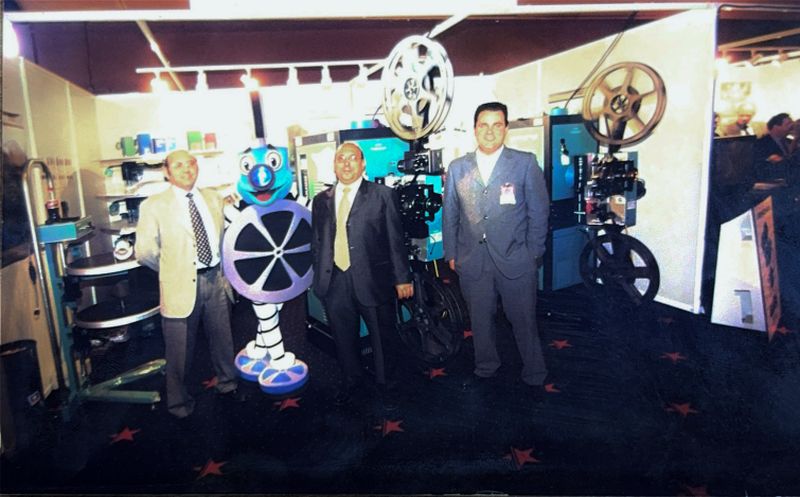 Three men in front of 35mm film projectors.
