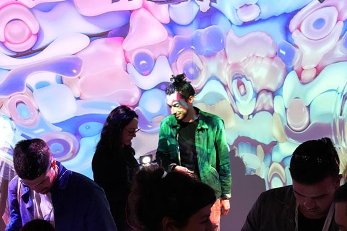 People standing in front of an immersive projection wall