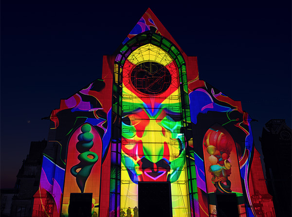 A colorful image projected onto the facade of a church